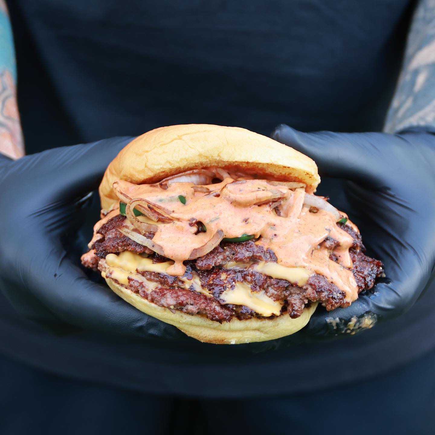 Double-stack smash burger with grilled onions and house spicy sauce
